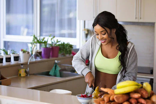 Woman slicing vegetables in a bright, modern kitchen.