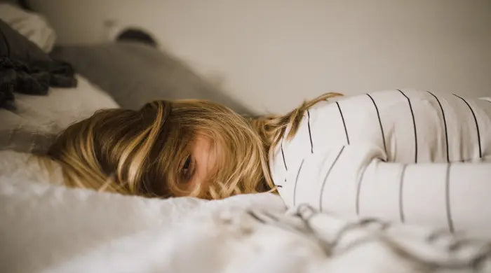 Woman lying in bed, face down