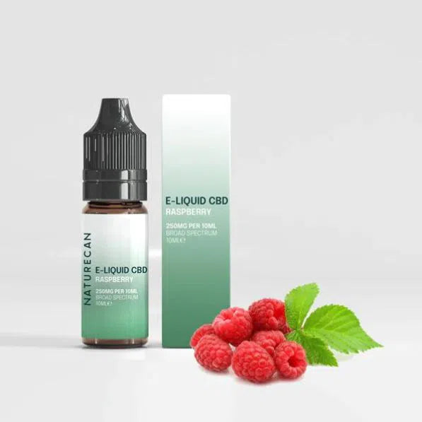 E-liquid CBD raspberry packaging with fresh raspberries beside the bottle.