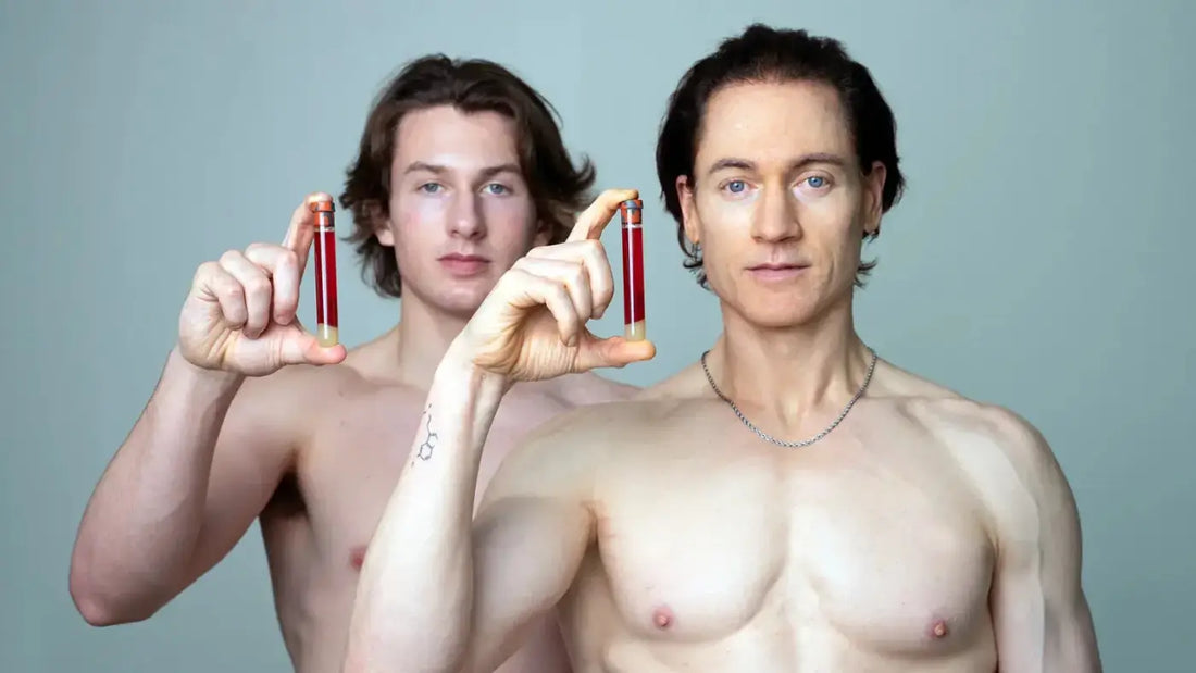 Bryan Johnson and his son holding a bottle of red liquid