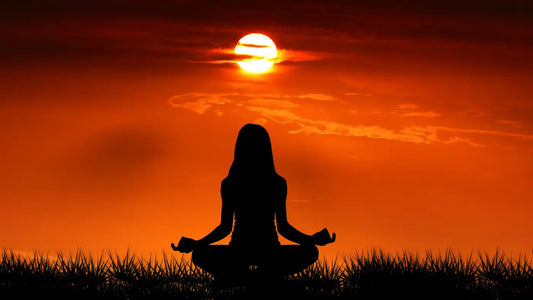 woman meditating at sunset