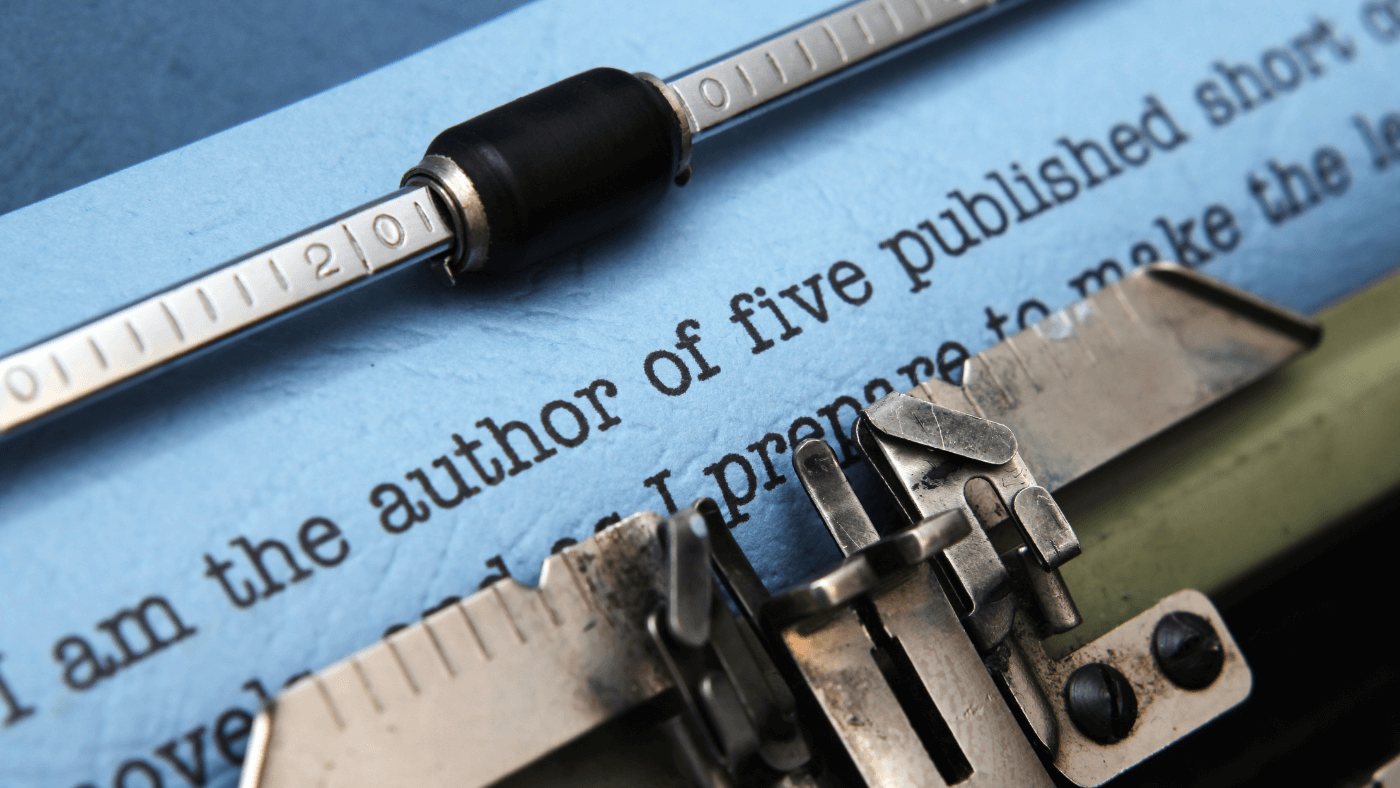 A vintage typewriter typing on blue paper with partially visible text.