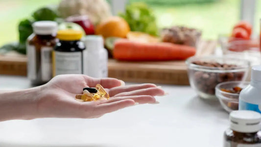 hand holding Anti-Ageing Supplements and in the background are shown Longevity foods and supplements