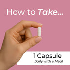 Hand holding a white capsule with text on a pink background