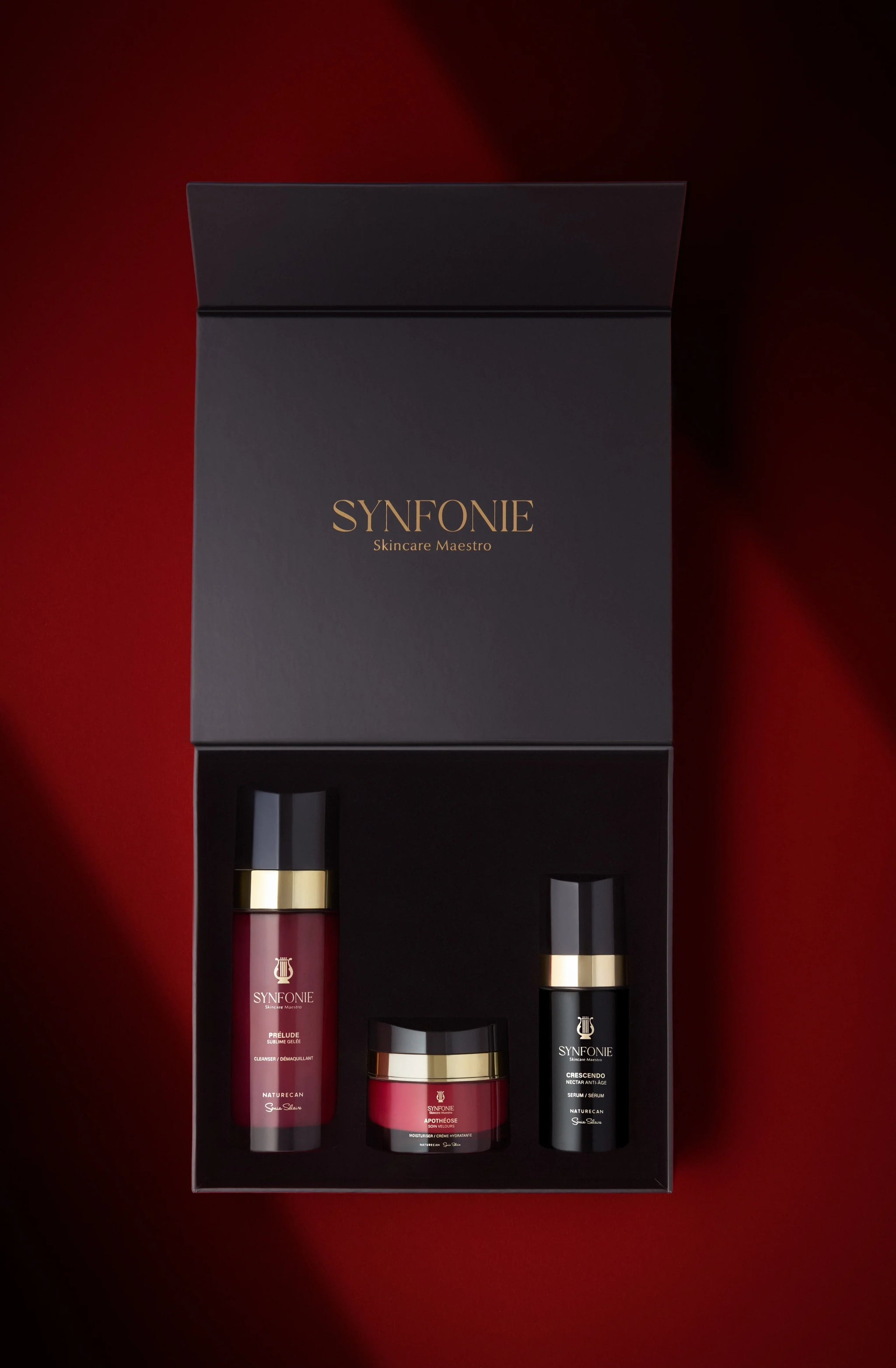 SYNFONIE skincare set with three products in a black box on a red background