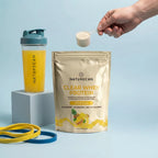 Naturecan Clear Whey Protein package with a shaker and protein powder on a light blue background