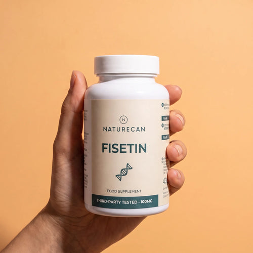A hand holding a white bottle of Naturecan Fisetin food supplement against a solid peach-colored background.