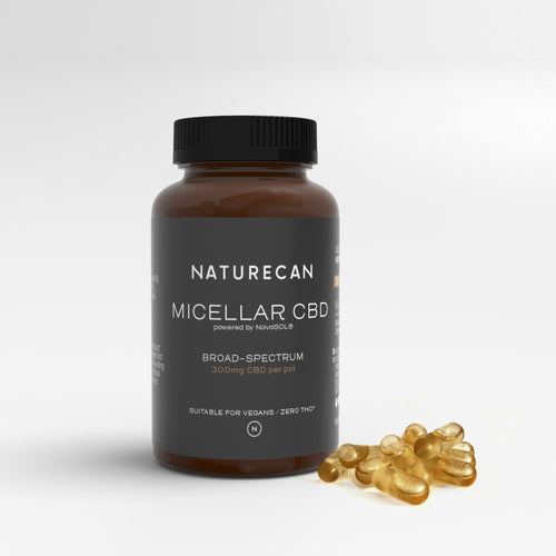 Naturecan Micellar CBD capsules bottle with scattered capsules, labeled broad-spectrum, suitable for vegans.