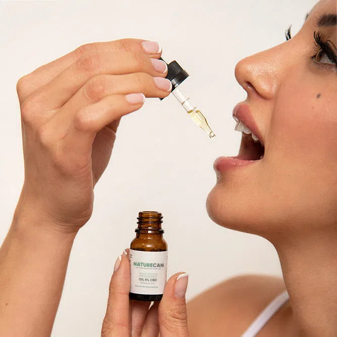 Person using a dropper to take Naturecan CBD oil.