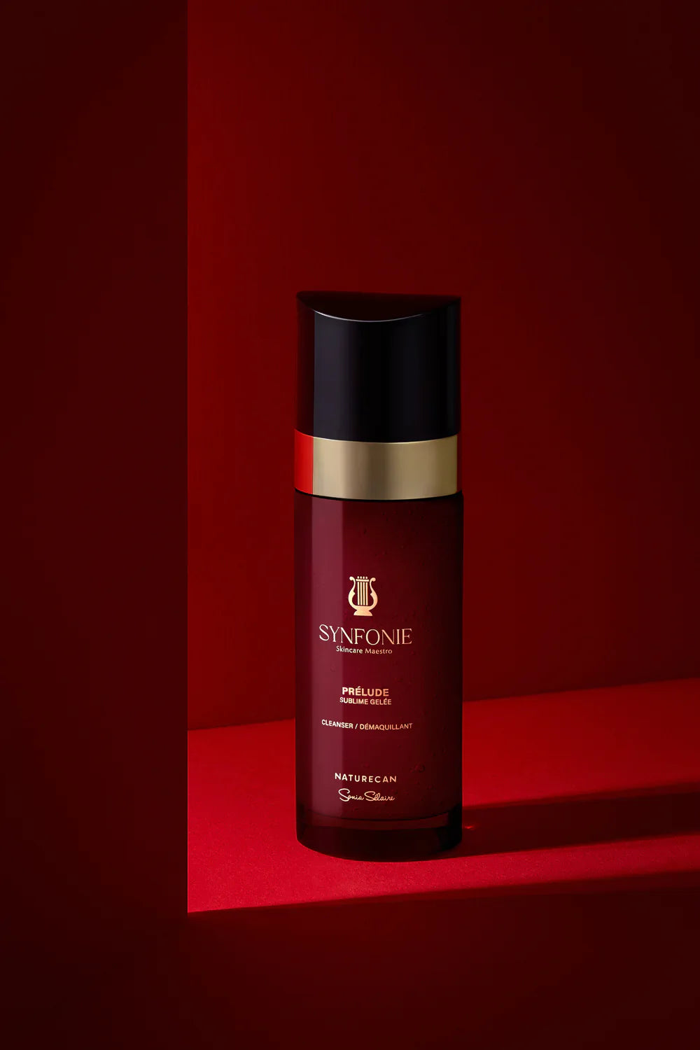 Red bottle with black cap on a red background